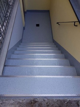 Treppensanierung: Kellertreppe (nachher) mit Kantenschutzprofilen und renoviertem Gully